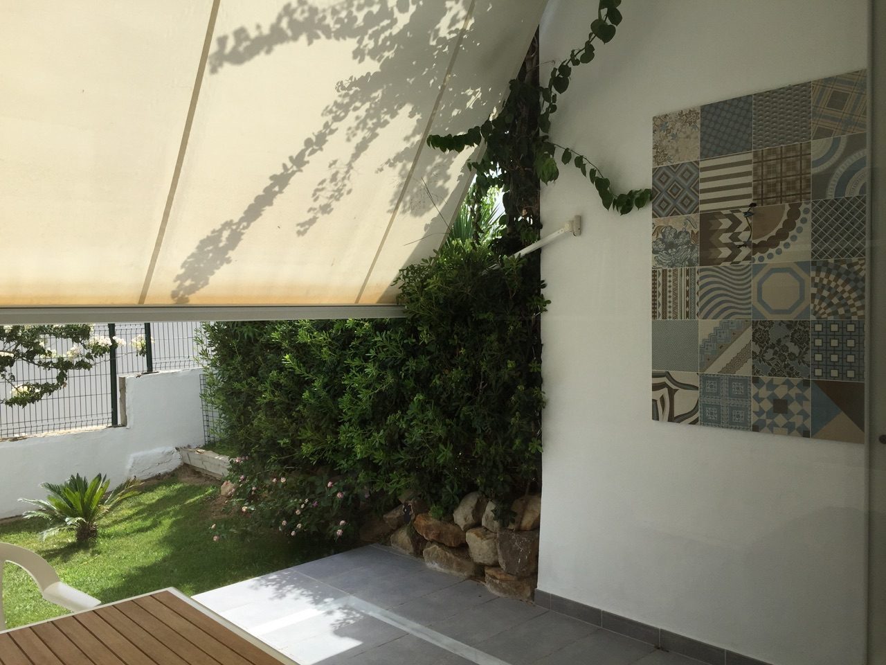 Überdachte Veranda mit Markise und Blick in den privaten Garten